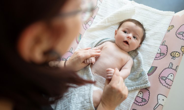 arts onderzoekt een baby tijdens consultatie