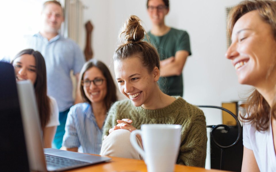 groep-collega-s-kijken-lachend-naar-computerscherm