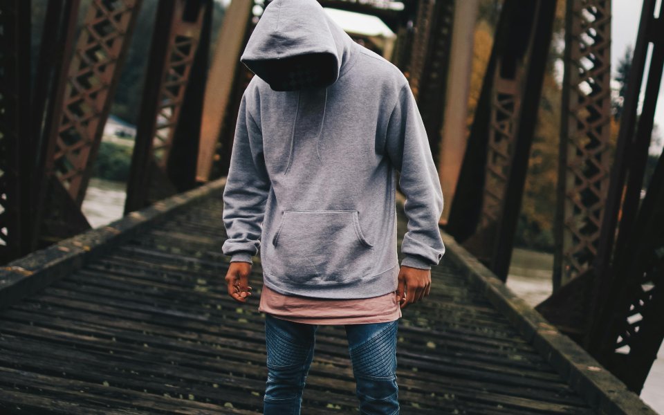 jongen-in-hoodie-op-houten-brug