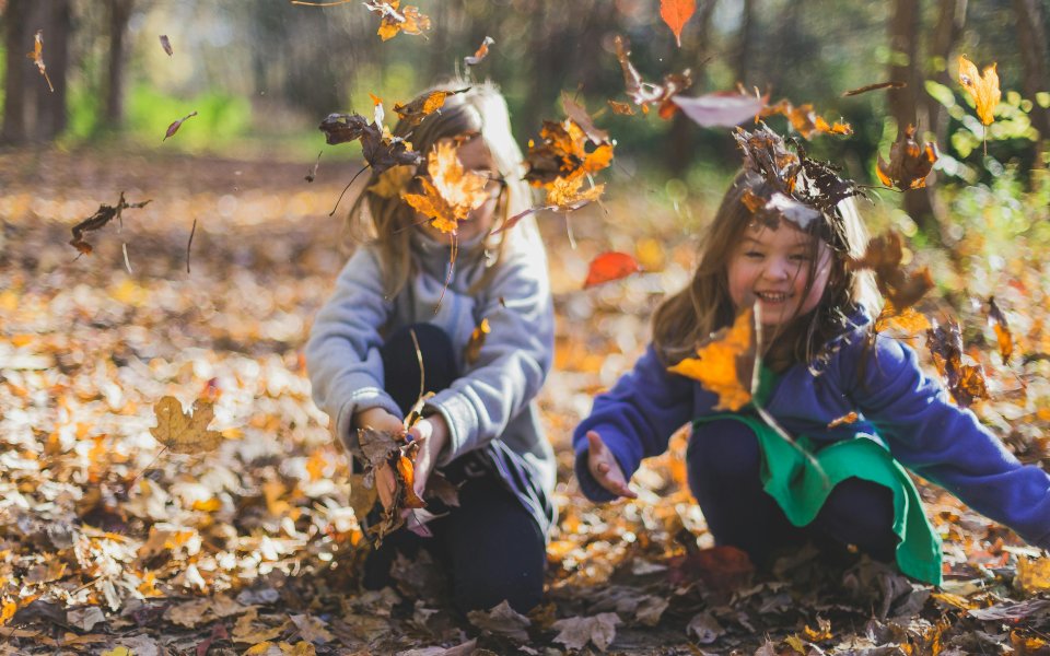 kinderen-gooien-met-herfstbladeren.