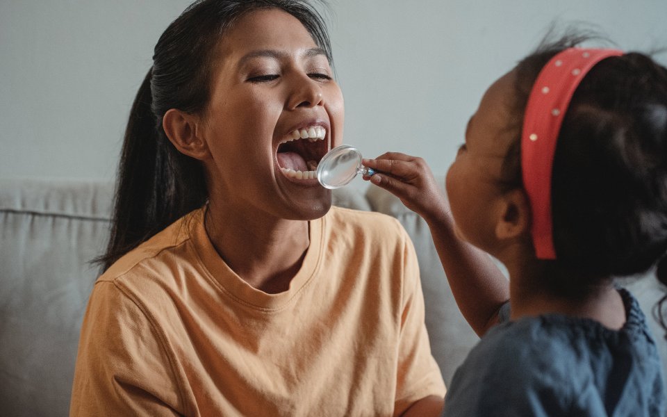 kindje-kijkt-met-doktersspatel-in-mond-mama