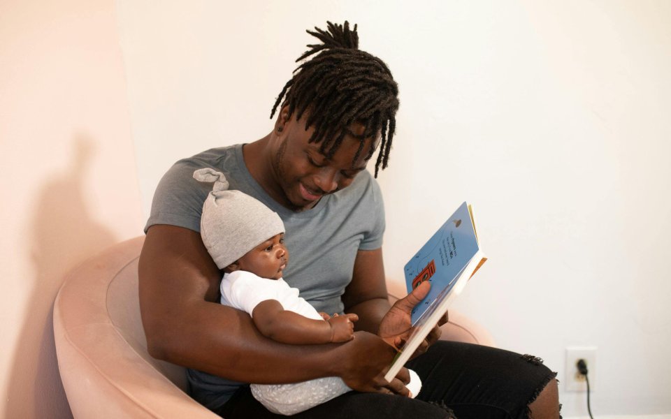 papa leest voor aan kleine baby op zijn schoot