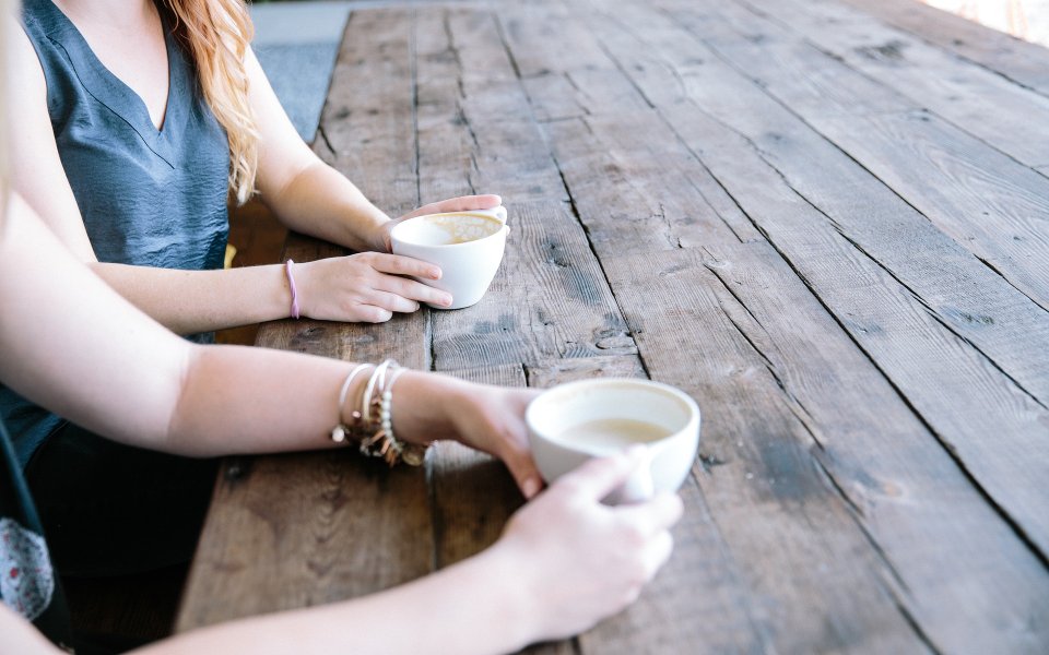 Kopjes koffie op tafel, gedronken door twee vrouwen